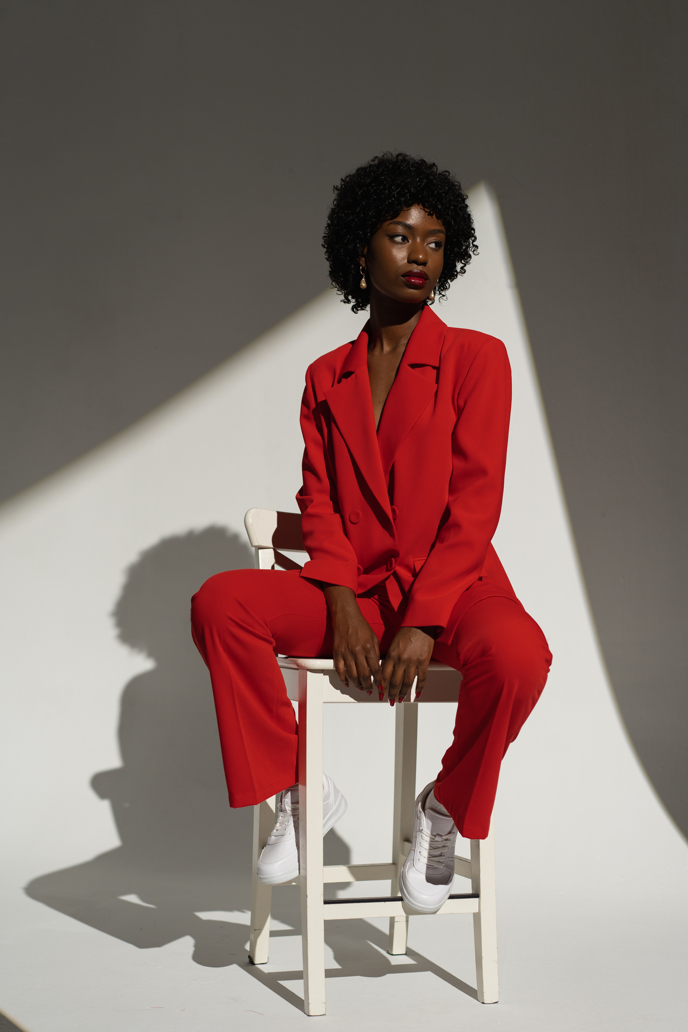 Fashionable Woman in Red Suit Sitting on the Chair